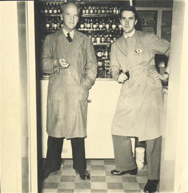 Interiör av apoteket med, från vänster, apotekare Axel Robert Gustafsson, laborant Per Elfvius (senare till S:t Erik).