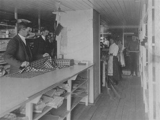 Arbete på tygavdelningen. Beställt tyg mäts upp.