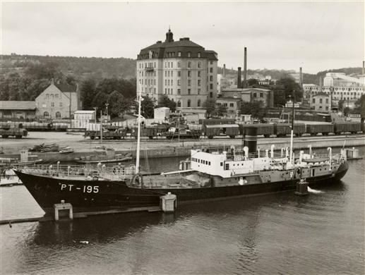 Fartyg, nyligen byggt på Ekensbergs varv, stävar förbi Liljeholmskajen på väg under Liljeholmsbron.