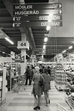 Interiör med kunder och mängder av orienteringsskyltar.